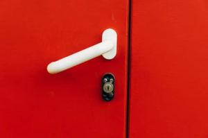 Lever handle and lock on a red door.